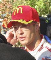 Bourdais saliendo del McDonald's, después de tomarse un Happy Meal y con una gorra de regalo